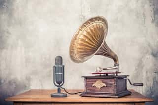 Vintage Antique Gramophone Phonograph Turntable With Brass Horn And Big Aged Studio Microphone On Wooden Table Front Concrete Wall Background  Retro Old Style Filtered Photo Wall Mural