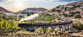 Glenfinnan Railway Viaduct In Scotland With The Jacobite Steam Train Against Sunset Over Lake   Wall Mural