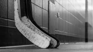 Black And White Macro Shot Of Hockey Stick Blades Laid On A Dirty Arena Floor - Shallow Depth Of Field Wall Mural