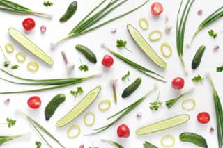 Abstract Composition Of Vegetables  Vegetable Pattern  Food Background  Top View  Large And Small Cucumbers, Garlic, Tomatoes And Green Onions On A White Background  Food Concept  Sliced Vegetables  Wall Mural