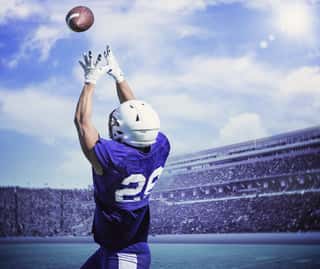 American Football Player Catching A Touchdown Pass In A Large Outdoor Football Stadium Wall Mural