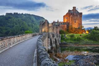 Eilean Donan Castle, Scotland, Reflecting Itself Into The Water During Evening  Wall Mural