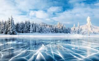 Blue Ice And Cracks On The Surface Of The Ice  Frozen Lake Under A Blue Sky In The Winter  The Hills Of Pines  Winter  Carpathian, Ukraine, Europe  Wall Mural
