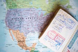 (Selective Focus) A Passport With Entry Stamps Is On A Blurred Geographical Map Of The World  The Map Shows The United States An Mexico Wall Mural
