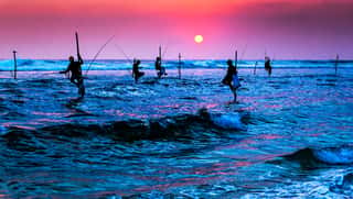 Silhouettes Of The Traditional Stilt Fishermen At The Sunset Near Galle In Sri Lanka Wall Mural