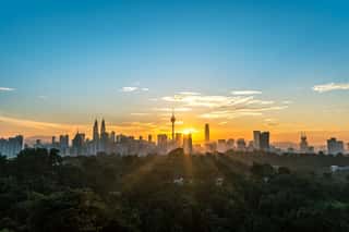 Cityscape Of Kuala Lumpur, Malaysia Surrounded By Trees During Sunrise Wall Mural