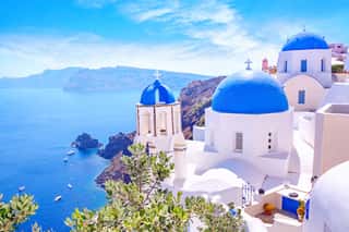 Beautiful Oia Town On Santorini Island, Greece  Traditional White Architecture  And Greek Orthodox Churches With Blue Domes Over The Caldera, Aegean Sea  Scenic Travel Background  Wall Mural