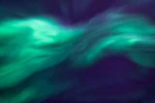 Shape Of Fast Moving Northern Lights Looking Up In The Sky Green Aurora Borealis In Dark Blue Sky Tromso, Norway Wall Mural