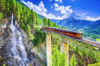 Zermatt, Switzerland  Gornergrat Tourist Train With Waterfall, Bridge And Matterhorn  Valais Region  Wall Mural