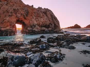 Image of Panoramic View Of The Keyhole Arch Cliff At Pfeiffer Big Sur State Park Beach In California  Black Rocks In The Foreground  Light Of The Setting Sun Creates An Amazing Red Glow On The Horizon  Canvas Print