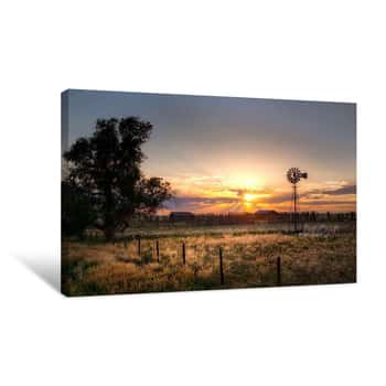 Image of Small Farm In A Rural Setting With The Sun Setting In The Background  There Are Cattle Drinking From A Water Hole  There Is Also A Windmill In The Scene   Canvas Print