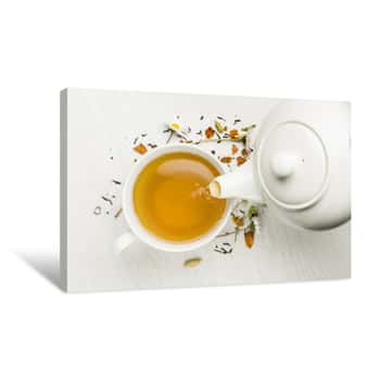 Image of Pouring Tea With Teapot Into Cup On White Table Canvas Print