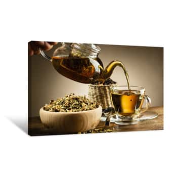 Image of Glass Teapot Pouring Tea Into Glass Cup On Wooden Table Canvas Print