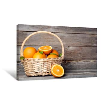 Image of Orange Fruit With Green Leaf In Basket On Grey Wooden Table Canvas Print