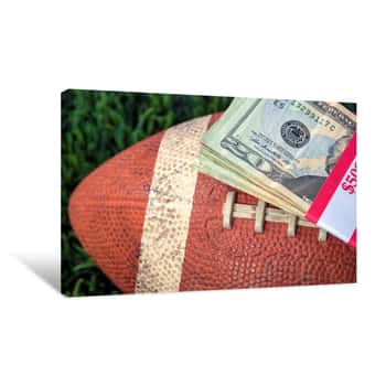 Image of Close Up Of Wrapped Money Stack On Used Football With Green Grass Background Canvas Print