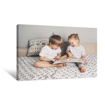 Image of Two Kids Sitting On Bed And Reading A Book Canvas Print