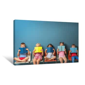 Image of Cute Little Children Reading Books While Sitting Near Color Wall Canvas Print