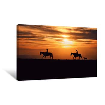 Image of Two Horse Riders In Front Of A Beautiful Sunset With A Dog Trailing Behind Canvas Print