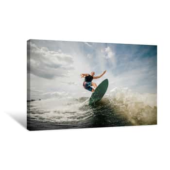 Image of Athletic Man Wakesurfing On The Board Against The Cloudy Sky Canvas Print
